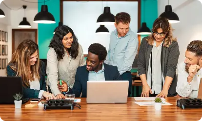 Team collaborating around a laptop